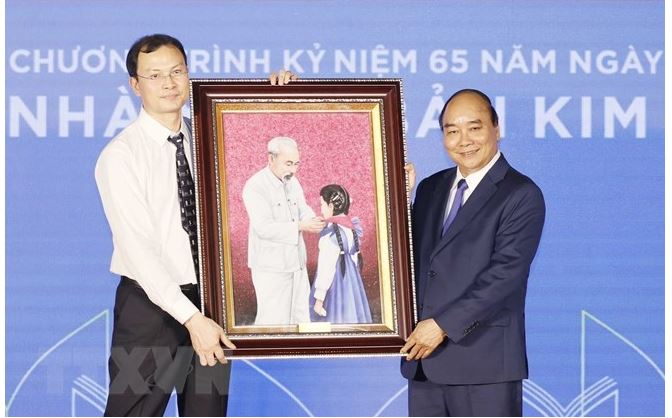 Chủ tịch nước tặng bức tranh "Bác Hồ với thiếu nhi" cho Nhà xuất bản Kim Đồng. (Ảnh: TTXVN)