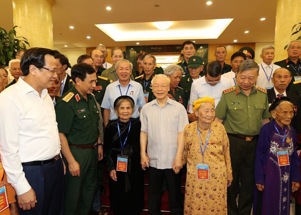 Tổng bí thư Nguyễn Phú Trọng cùng lãnh đạo các bộ, ngành chụp ảnh lưu niệm với đại diện người có công tiêu biểu, chiều 23/7. Ảnh: TTXVN