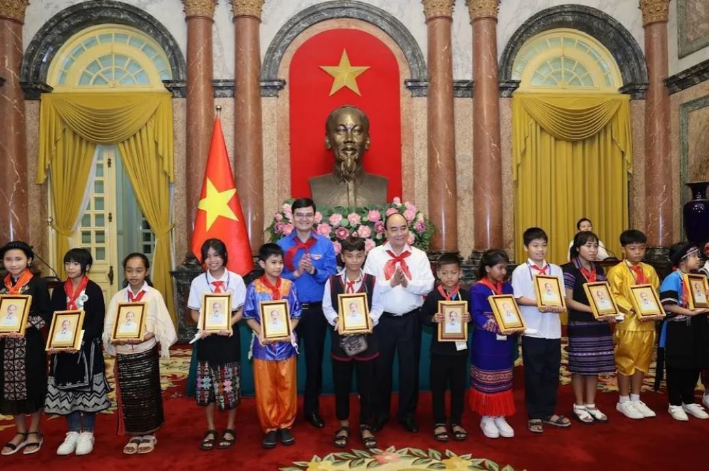 Chủ tịch nước Nguyễn Xuân Phúc và Bí thư thứ nhất T.Ư Đoàn Bùi Quang Huy tặng quà cho các cháu thiếu nhi tại buổi gặp mặt.