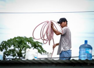 Người dân cột các thùng nước trên mái nhà để phòng tránh bão