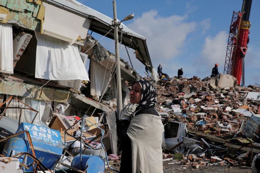 Mot nguoi phu nu dung truoc toa nha do nat - Cập nhật động đất Thổ Nhĩ Kỳ-Syria: Hơn 7.800 người chết, Thổ Nhĩ Kỳ ban bố tình trạng khẩn cấp trong 3 tháng