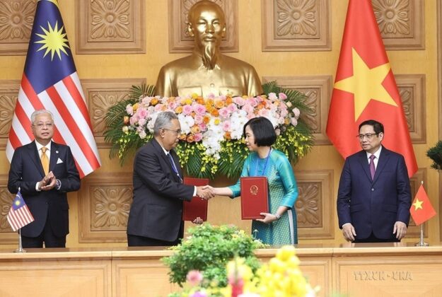 Tổng Gi&aacute;m đốc TTXVN Vũ Việt Trang v&agrave; Tổng Bi&ecirc;n tập H&atilde;ng th&ocirc;ng tấn quốc gia Malaysia (BERNAMA) Khairdzir Md Yunus trao đổi Thỏa thuận hợp t&aacute;c nghiệp vụ giữa 2 h&atilde;ng th&ocirc;ng tấn trước sự chứng kiến của Thủ tướng Phạm Minh Ch&iacute;nh v&agrave; Thủ tướng Malaysia Dato Sri Ismail Sabri bin Yaakob, ng&agrave;y 21/3/2022. (Ảnh: Dương Giang/TTXVN)