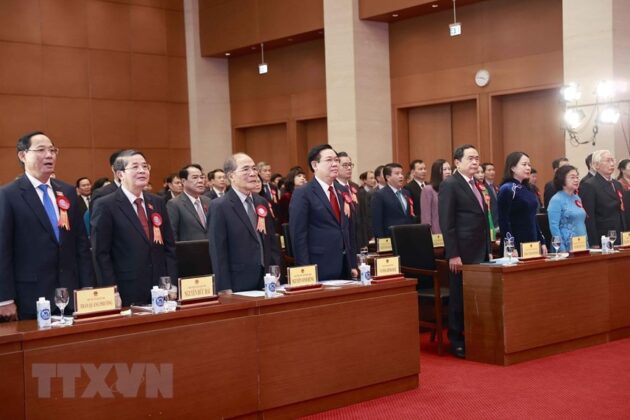 Chủ tịch Quốc hội Vương Đ&igrave;nh Huệ v&agrave; c&aacute;c đại biểu thực hiện nghi thức ch&agrave;o cờ tại lễ kỷ niệm. (Ảnh: Do&atilde;n Tấn/TTXVN)