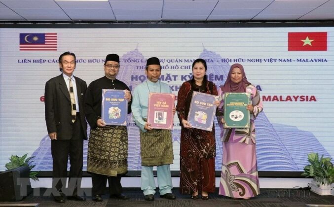 Tổng l&atilde;nh sự Wong Chia Chiann v&agrave; c&aacute;c nh&acirc;n vi&ecirc;n Tổng l&atilde;nh sự qu&aacute;n Malaysia tại TP Hồ Ch&iacute; Minh nhận s&aacute;ch giới thiệu về Tết truyền thống Việt Nam tại buổi họp mặt kỷ niệm lần thứ 65 ng&agrave;y Quốc kh&aacute;nh Malaysia, ng&agrave;y 9/9/2022. (Ảnh: Xu&acirc;n Khu/TTXVN)