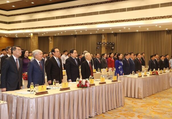 Tổng B&iacute; thư Nguyễn Ph&uacute; Trọng c&ugrave;ng c&aacute;c l&atilde;nh đạo Đảng, Nh&agrave; nước v&agrave; c&aacute;c đại biểu thực hiện nghi lễ ch&agrave;o cờ. (Ảnh: Tr&iacute; Dũng/TTXVN)
