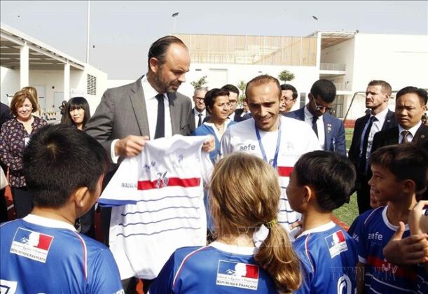 Học sinh Trường Quốc tế Ph&aacute;p Alexandre Yersin (quận Long Bi&ecirc;n, H&agrave; Nội) tặng Thủ tướng Ph&aacute;p &Eacute;douard Philippe chiếc &aacute;o thể thao nh&acirc;n dịp Thủ tướng đến thăm v&agrave; cắt băng kh&aacute;nh th&agrave;nh Trường, ng&agrave;y 3/11/2018. Ảnh: Văn Điệp/TTXVN