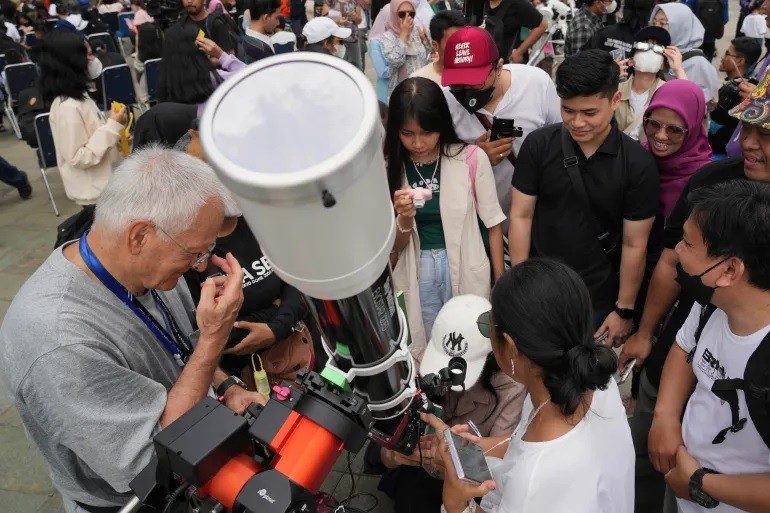 Người dân ở Jakarta, Indonesia thay phiên nhau sử dụng kính viễn vọng để xem nhật thực một phần.