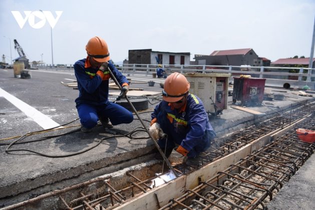 Tr&ecirc;n c&ocirc;ng trường, dưới c&aacute;i nắng như đổ lửa, c&ocirc;ng nh&acirc;n vẫn miệt m&agrave;i gấp r&uacute;t thi c&ocirc;ng những hạng mục cuối c&ugrave;ng về an to&agrave;n giao th&ocirc;ng, sơn vạch kẻ đường, khe c&otilde; gi&atilde;n.