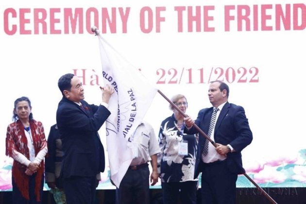 Ph&oacute; Chủ tịch thường trực Quốc hội Trần Thanh Mẫn k&yacute; l&ecirc;n l&aacute; cờ của Hội đồng H&ograve;a B&igrave;nh thế giới tại Lễ khai mạc Đại hội lần thứ 22 Hội đồng H&ograve;a b&igrave;nh thế giới, tổ chức tại H&agrave; Nội, năm 2022. (Ảnh: Minh Đức/TTXVN)