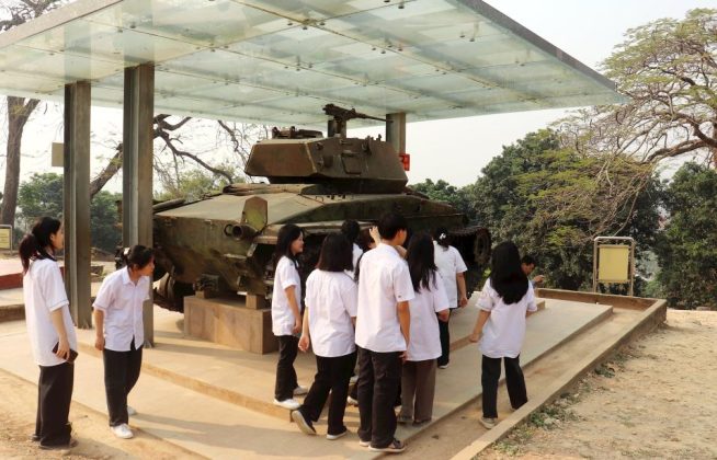 Các học sinh tham quan di tích Đồi A1. Nơi đây trưng bày xác một trong hai xe tăng nặng 18 tấn được Pháp đưa từ trung tâm Mường Thanh lên để phản kích quân đội ta.