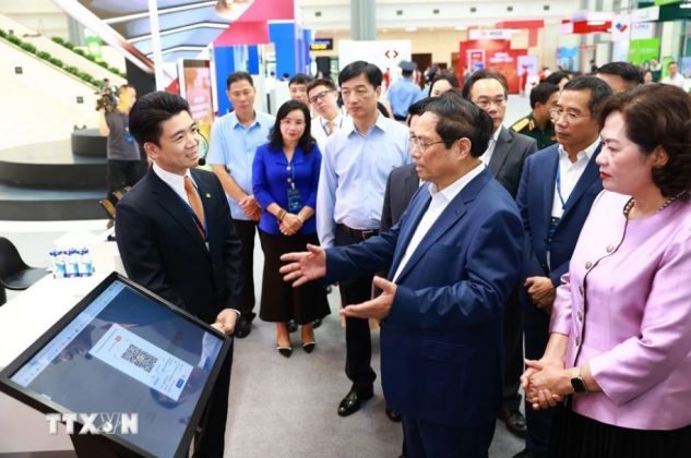 Thủ tướng Phạm Minh Ch&iacute;nh tham quan trưng b&agrave;y về ứng dụng chuyển đổi số trong lĩnh vực ng&acirc;n h&agrave;ng.
