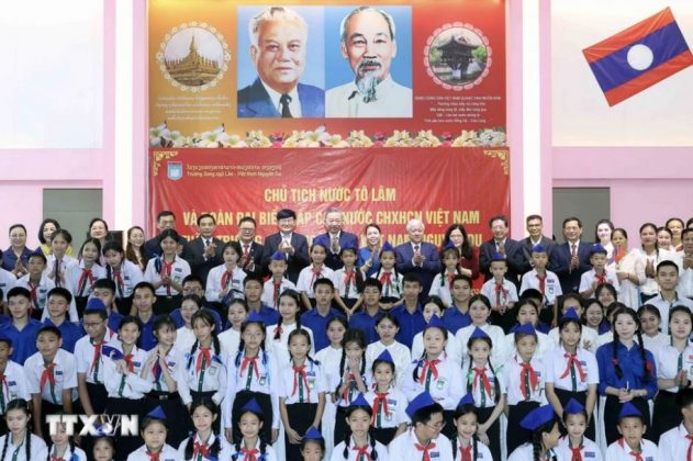 Chủ tịch nước T&ocirc; L&acirc;m v&agrave; c&aacute;c đại biểu chụp ảnh chung với thầy c&ocirc; gi&aacute;o v&agrave; học sinh Trường song ngữ L&agrave;o-Việt Nam.