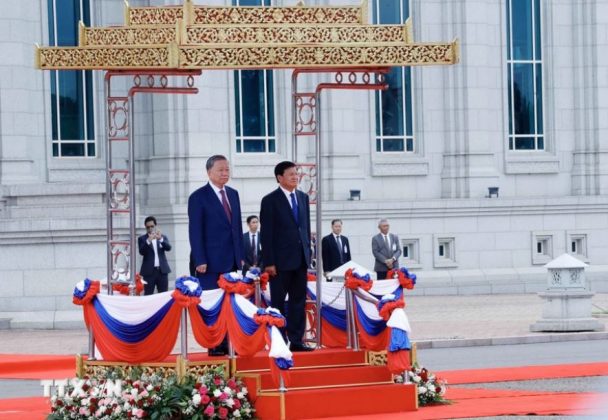 Chủ tịch nước T&ocirc; L&acirc;m v&agrave; Tổng B&iacute; thư, Chủ tịch nước L&agrave;o Thongloun Sisoulith tr&ecirc;n bục danh dự, nghe qu&acirc;n nhạc cử Quốc thiều hai nước. (Ảnh: Nhan S&aacute;ng/TTXVN)