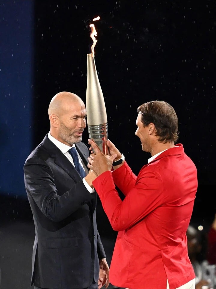 Huyền thoại bóng đá Pháp Zinedine Zidane trao ngọn lửa Olympic cho tay vợt người Tây Ban Nha Rafael Nadal.