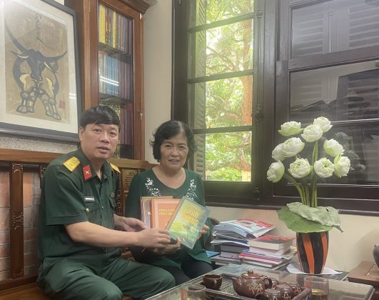 Nh&agrave; văn Ph&ugrave;ng Văn Khai (b&igrave;a tr&aacute;i) trao tặng s&aacute;ch cho độc giả.
