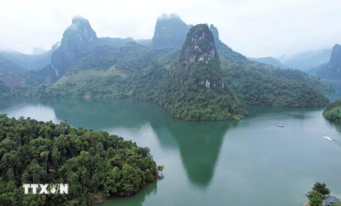 Vịnh P&aacute; Kh&ocirc;m nh&igrave;n từ tr&ecirc;n cao tr&ocirc;ng như một bức tranh sơn thủy hữu t&igrave;nh với những d&atilde;y n&uacute;i đ&aacute; v&ocirc;i in b&oacute;ng dưới l&agrave;n nước xanh biếc.