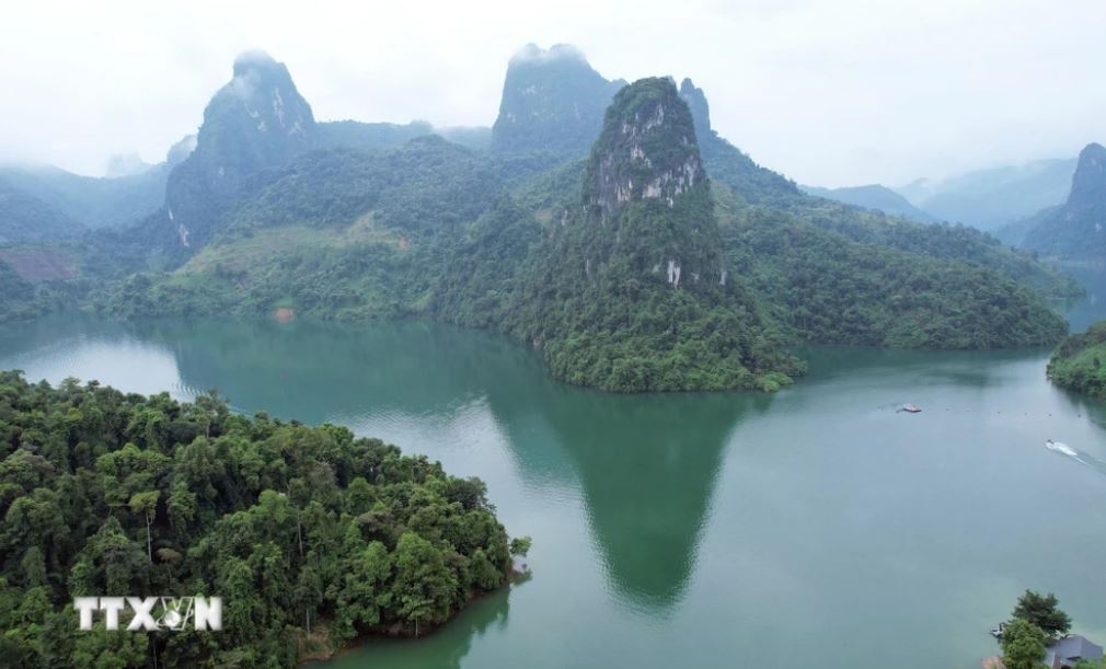 Vịnh Pá Khôm nhìn từ trên cao trông như một bức tranh sơn thủy hữu tình với những dãy núi đá vôi in bóng dưới làn nước xanh biếc.