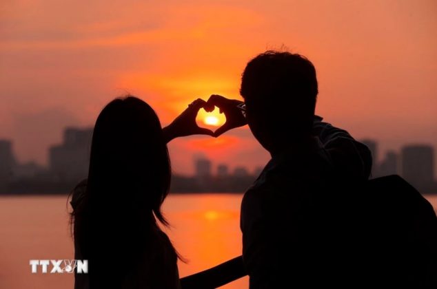 Đ&ocirc;i bạn trẻ tận hưởng cảnh sắc m&ugrave;a Thu H&agrave; Nội đầy l&atilde;ng mạn. (Ảnh: Minh Quyết/ TTXVN)