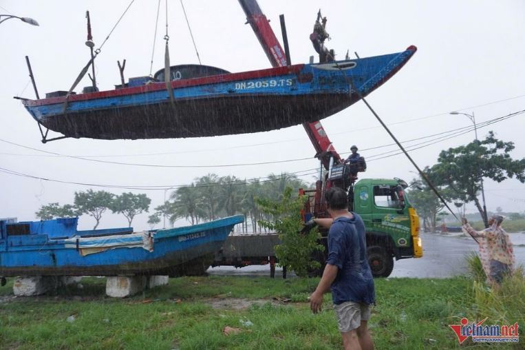 Người dân đưa thuyền lên bờ để ứng phó với áp thấp nhiệt đới có thể mạnh lên thành bão. Ảnh: Hà Nam.