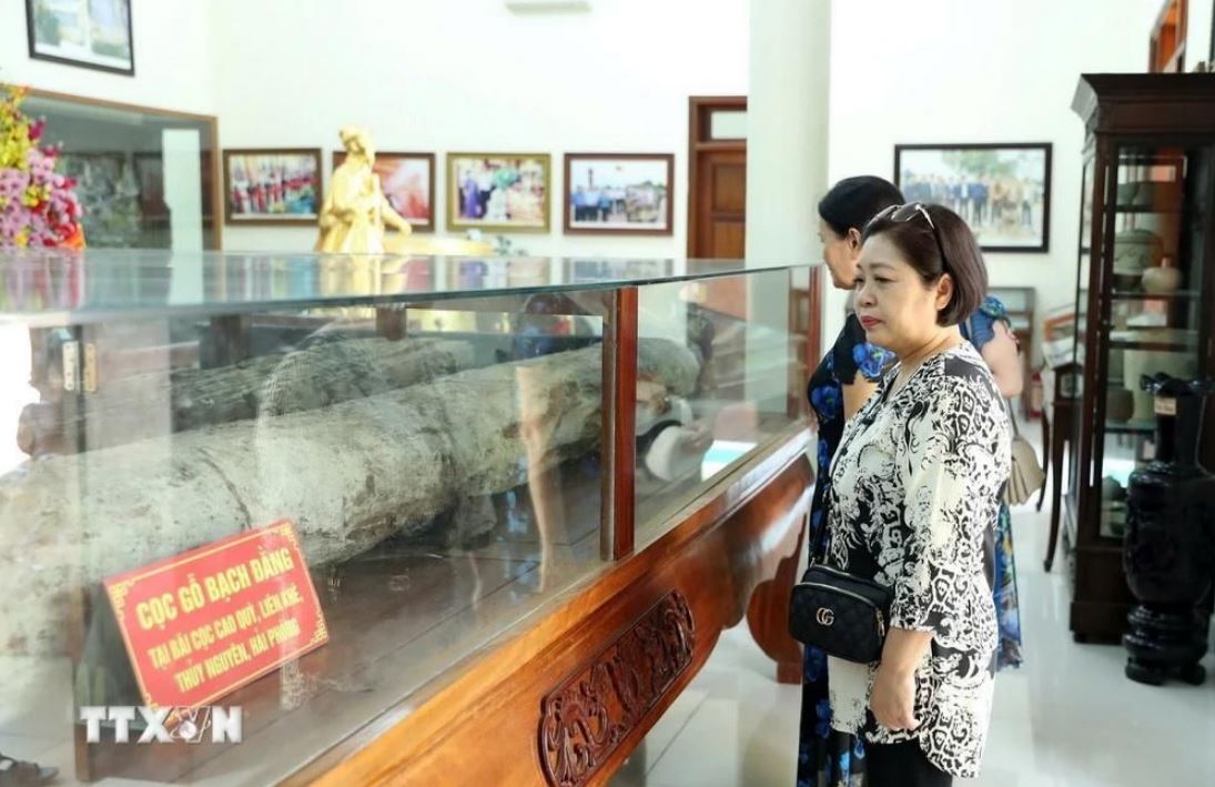 Du khách tham quan hiện vật cọc Bạch Đằng được bảo tồn nguyên trạng tại khu di tích. (Ảnh: Hoàng Hiếu/TTXVN)