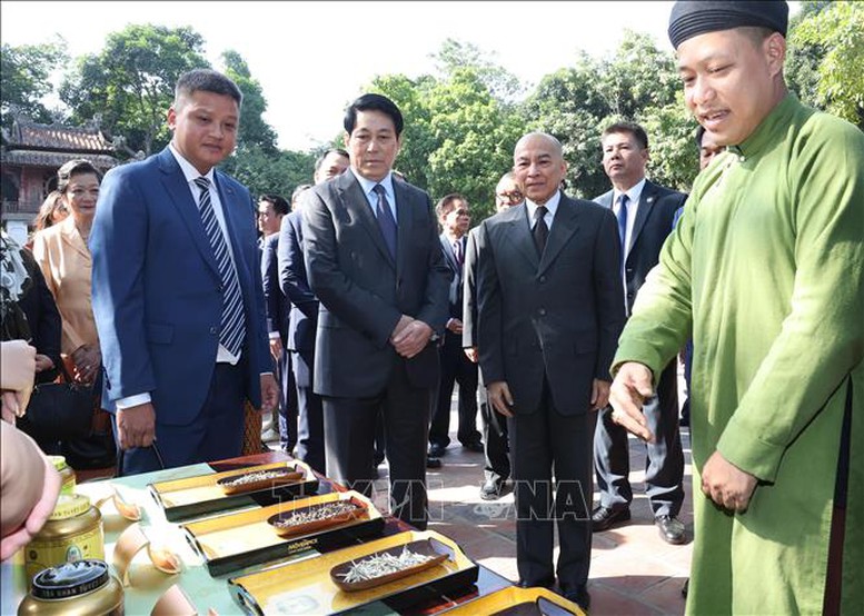 Chủ tịch nước Lương Cường và Quốc vương Campuchia Norodom Sihamoni nghe giới thiệu về trà quý của Việt Nam - Ảnh: TTXVN