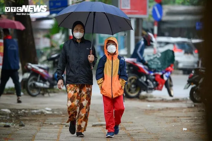 Người dân mặc áo ấm ra đường khi trời trở lạnh. 