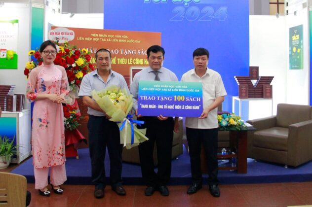 Nh&agrave; văn, nh&agrave; nghi&ecirc;n cứu Nguyễn Xu&acirc;n Tuấn (cầm hoa) tại buổi ra mắt - trao tặng s&aacute;ch &ldquo;Danh nh&acirc;n - &Ocirc;ng tổ nghề th&ecirc;u L&ecirc; C&ocirc;ng H&agrave;nh.