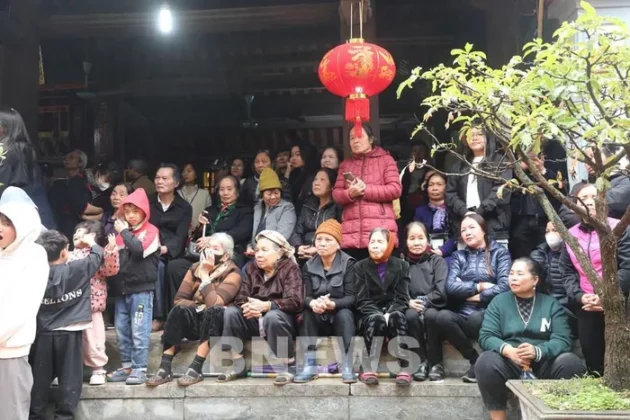 C&aacute;c cụ gi&agrave; v&agrave; người d&acirc;n đang ngồi đợi ở đ&igrave;nh l&agrave;ng Thổ H&agrave; chờ đo&agrave;n rước lễ về. Ảnh: Đức Hạnh/BNEWS/TTXVN