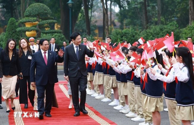 Thủ tướng Phạm Minh Ch&iacute;nh v&agrave; Phu nh&acirc;n c&ugrave;ng Thủ tướng Singapore Lawrence Wong v&agrave; Phu nh&acirc;n với thiếu nhi Thủ đ&ocirc;.