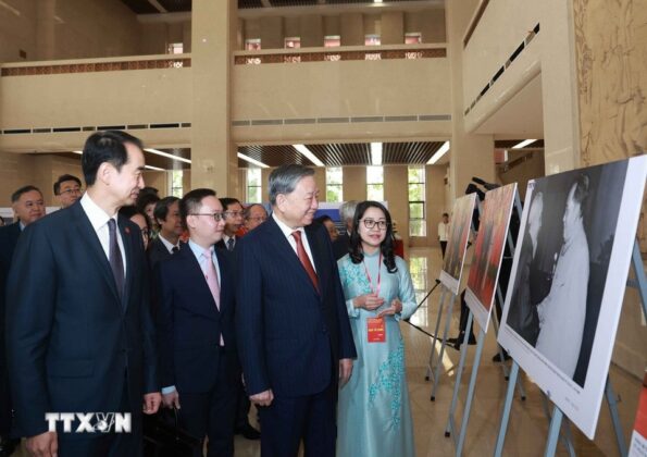 Tổng B&iacute; thư T&ocirc; L&acirc;m xem trưng b&agrave;y ảnh về th&agrave;nh tựu 75 năm quan hệ Việt-Trung, do TTXVN thực hiện. (Ảnh: Thống Nhất/TTXVN)