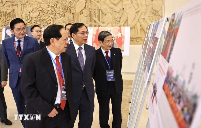 C&aacute;c đại biểu xem trưng b&agrave;y ảnh về th&agrave;nh tựu 75 năm quan hệ Việt-Trung do TTXVN thực hiện. (Ảnh: Minh Đức/TTXVN)