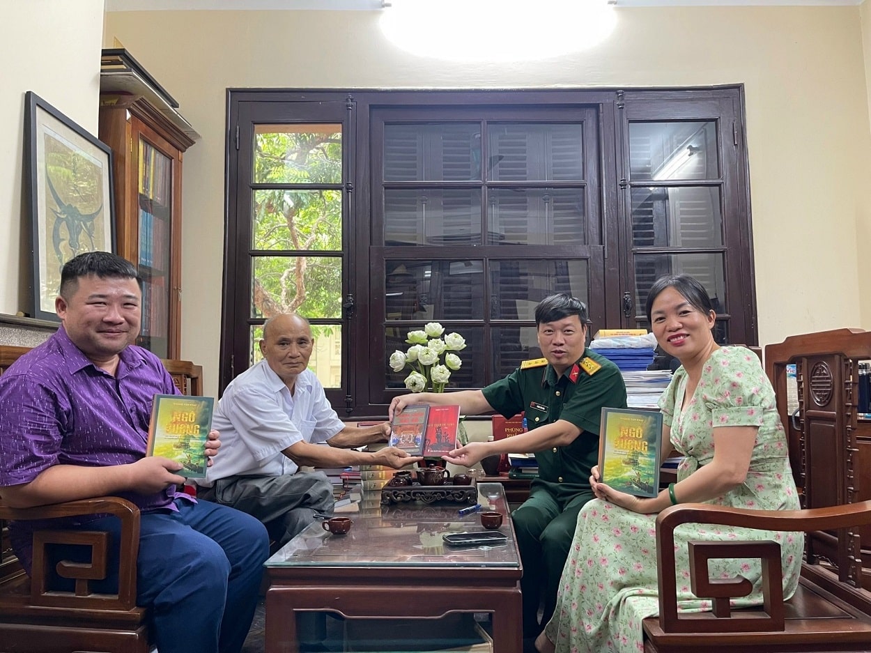 Nhà văn Phùng Văn Khai (mặc quân phục) tặng sách tại văn phòng làm việc.