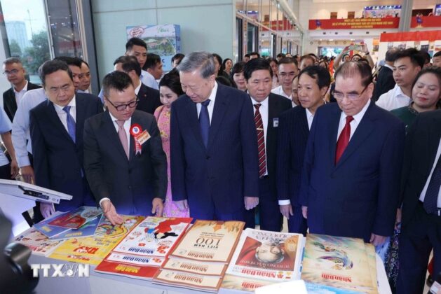 Tổng B&iacute; thư T&ocirc; L&acirc;m v&agrave; c&aacute;c đồng ch&iacute; l&atilde;nh đạo tham quan gian trưng b&agrave;y b&aacute;o Nh&acirc;n D&acirc;n. (Ảnh: Phương Hoa/TTXVN)
