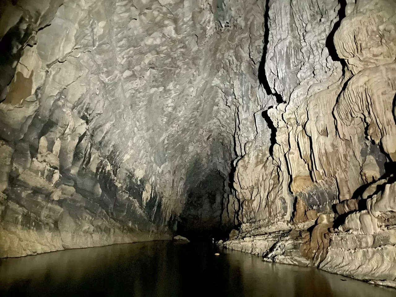 Bên trong hang là thế giới của những dải thạch nhũ như rèm buông, hồ nước bậc thang dài tới 61m, cùng vô số cấu trúc địa chất độc đáo. Ngoài cửa hang là hồ nước rộng 200m, được người dân bảo tồn làm khu sinh sản cá, đóng vai trò quan trọng trong sinh kế địa phương. (Nguồn: GIZ ProFEB)