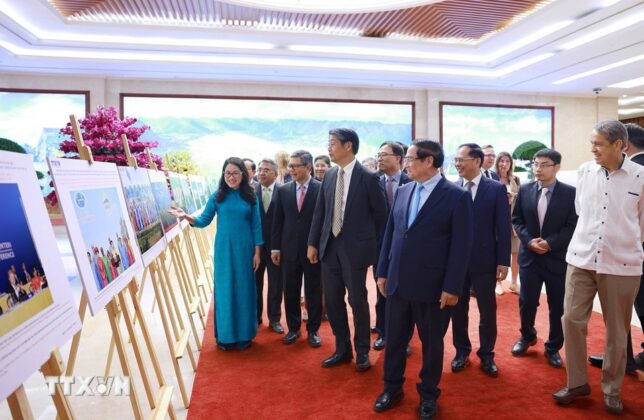 Thủ tướng Phạm Minh Ch&iacute;nh v&agrave; c&aacute;c đại biểu xem trưng b&agrave;y ảnh về vai tr&ograve; v&agrave; những đ&oacute;ng g&oacute;p t&iacute;ch cực của Việt Nam từ khi gia nhập APEC c&ugrave;ng c&ocirc;ng t&aacute;c chuẩn bị APEC 2027. (Ảnh: Dương Giang/TTXVN)