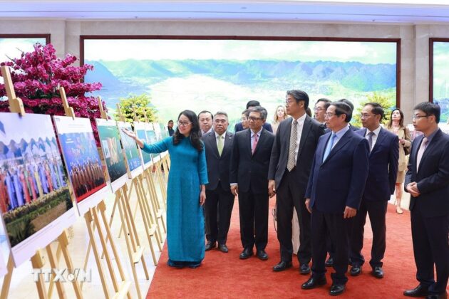 Thủ tướng Phạm Minh Ch&iacute;nh v&agrave; c&aacute;c đại biểu xem trưng b&agrave;y ảnh về vai tr&ograve; v&agrave; những đ&oacute;ng g&oacute;p t&iacute;ch cực của Việt Nam từ khi gia nhập APEC c&ugrave;ng c&ocirc;ng t&aacute;c chuẩn bị APEC 2027. (Ảnh: Dương Giang/TTXVN)
