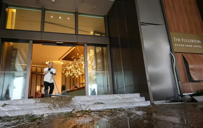 C&aacute;c video tại kh&aacute;ch sạn Fullerton ở ph&iacute;a Nam Hong Kong (Trung Quốc) cho thấy nước biển tr&agrave;n v&agrave;o sảnh qua cửa k&iacute;nh. Ch&iacute;nh quyền y&ecirc;u cầu người d&acirc;n ở trong nh&agrave;, đồng thời mở 49 điểm tr&uacute; ẩn tạm thời, tiếp nhận h&agrave;ng trăm người tr&aacute;nh b&atilde;o. Trong ảnh: Nh&acirc;n vi&ecirc;n Kh&aacute;ch sạn Fullerton ở Aberdeen dọn dẹp sau khi s&oacute;ng lớn l&agrave;m vỡ k&iacute;nh v&agrave; ngập sảnh. (Nguồn: SCMP)