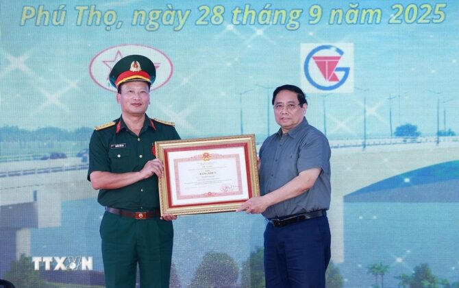 Thủ tướng Phạm Minh Ch&iacute;nh tặng bằng khen cho đồng ch&iacute; Nguyễn Tuấn Anh, Ph&oacute; Tư lệnh Binh đo&agrave;n 12, Bộ Quốc ph&ograve;ng c&oacute; th&agrave;nh t&iacute;ch xuất sắc trong tổ chức thi c&ocirc;ng dự &aacute;n cầu Phong Ch&acirc;u mới. (Ảnh: Dương Giang/TTXVN)