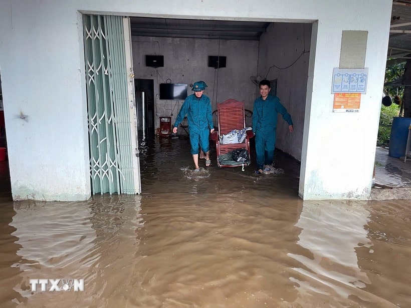 Lực lượng dân quân hỗ trợ người dân di chuyển đồ đạc khỏi vùng ngập lụt ven sông Krông Nô, tỉnh Lâm Đồng.