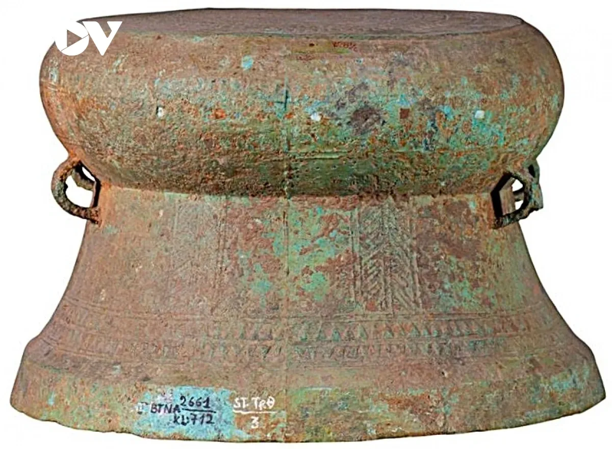 Trống Làng Vạc III, thuộc dòng trống thấp lưng choãi, với tang phình, lưng hình nón cụt choãi dần xuống dưới. Trống có 2 đôi quai bố trí ở hai bên thân, mỗi quai được trang trí hai hàng hoa văn bông lúa. Pa tin màu xanh rỉ đồng. (Ảnh: Bảo tàng Nghệ An cung cấp).